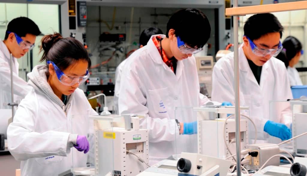 student wearing lab gown working at the laboratory
